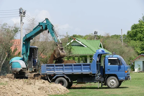 Excavator is loading dirt on truck — Stock Photo, Image