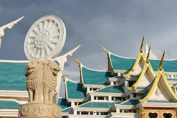 Löwenstatue und Gesetzesrad vor buddhistischer Kirche — Stockfoto