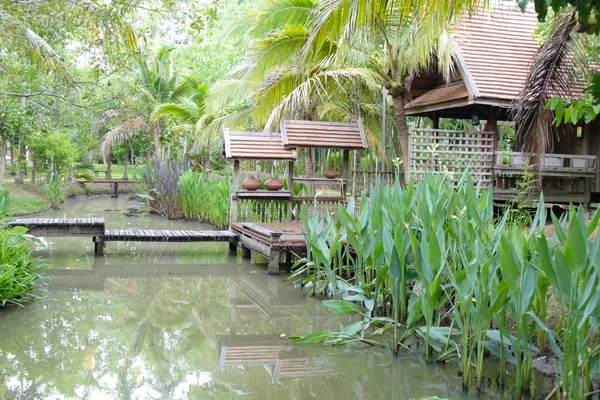 Puente de madera sobre el estanque y tailandia casa tradicional — Foto de Stock