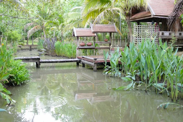 Puente de madera sobre el estanque y tailandia casa tradicional — Foto de Stock