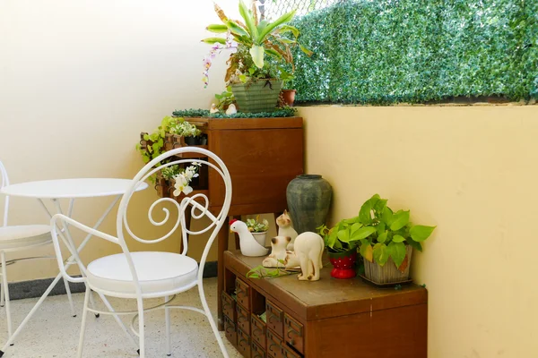 Białe krzesło i biurko i rośliny dekoracyjne na szuflady drewniane biurko — Zdjęcie stockowe