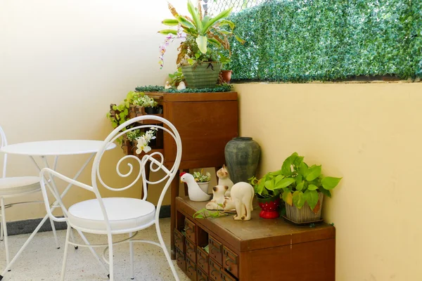 Cadeira branca e mesa e planta decoração na gaveta de mesa de madeira — Fotografia de Stock