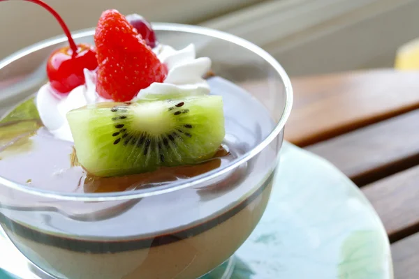 Mousse di budino al cioccolato guarnita con frutta e panna montata — Foto Stock