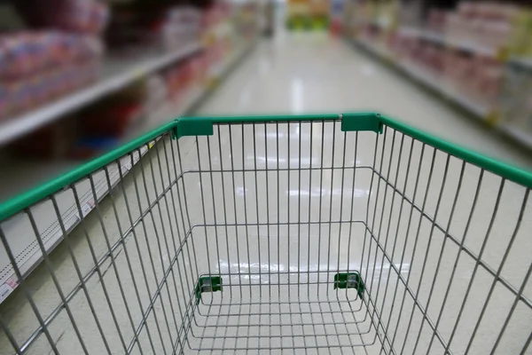 Cart in aisle of supermarket — Stock Photo, Image