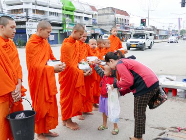 İnsanlar gıda Budist rahip için sunuyoruz.