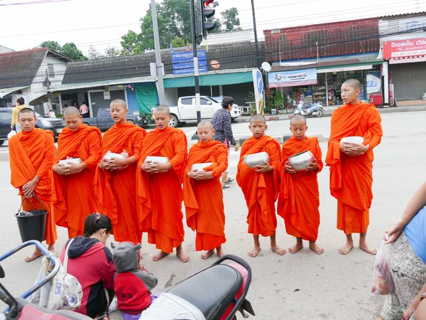 Люди предлагают еду буддистскому монаху — стоковое фото