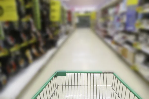 Cart in blurry defocused supermarket — Stock Photo, Image