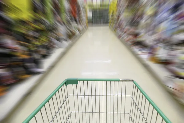 Cart in blurry defocused supermarket — Stock Photo, Image