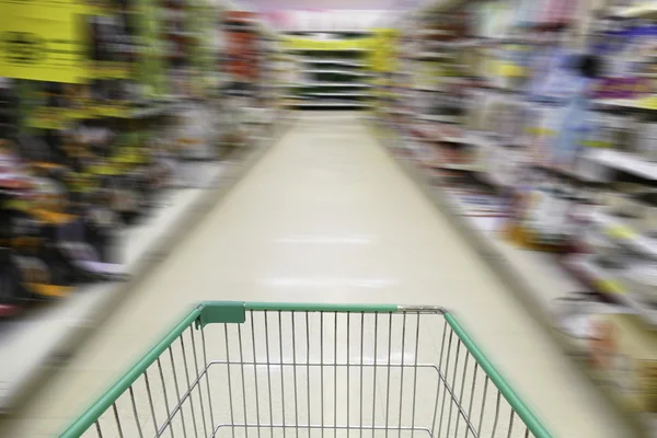 Cart in blurry defocused supermarket — Stock Photo, Image