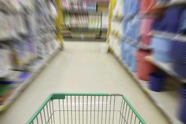 Cart in blurry defocused supermarket — Stock Photo, Image