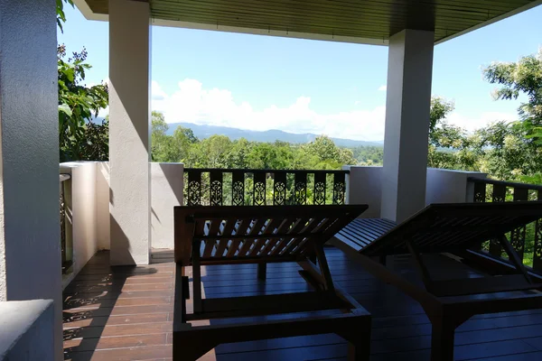 Tumbona de madera en el balcón con vista al bosque y al cielo — Foto de Stock