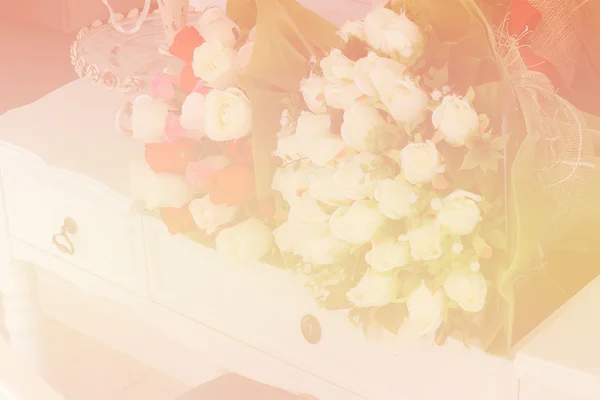 Фальшива троянда на білому туалетному столі (кольоровий фільтр і м'який фокус ) — стокове фото