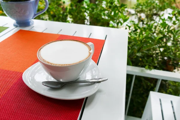 Café cappuccino chaud en tasse en céramique blanche sur table en bois blanc — Photo