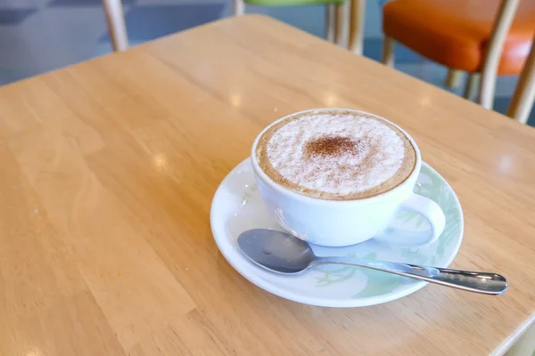 Hete cappuccino koffie in een beker met schotel en lepel — Stockfoto