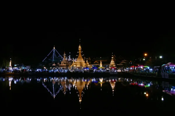 Świątynia z refleksji nad staw i chodzenie w nocy ulica znak — Zdjęcie stockowe