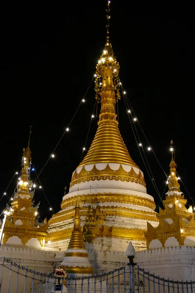 Hvit og gyllen buddhistisk pagoda-monument om natten – stockfoto