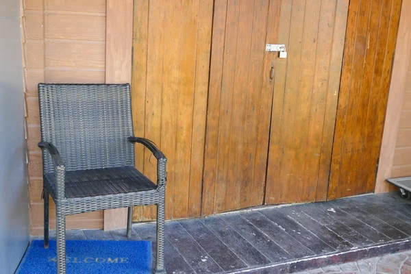 Fekete fonott szék mellett a fából készült fal — Stock Fotó