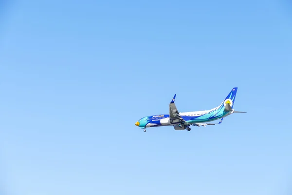 The airplane is flying in blue sky — Stock Photo, Image