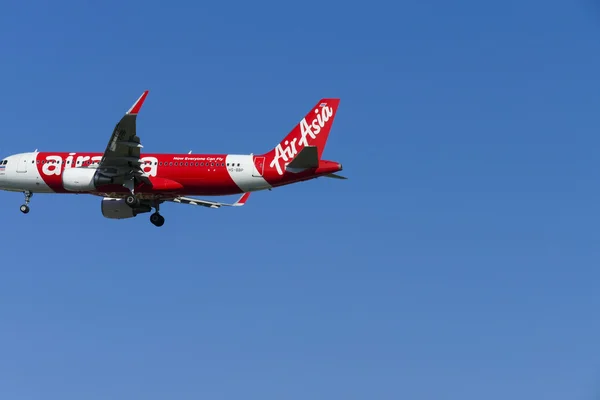 The airplane of Air Asia is flying in blue sky — Stock Photo, Image