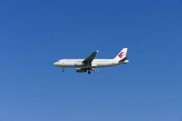 O avião da China Eastern Airlines está voando no céu azul — Fotografia de Stock