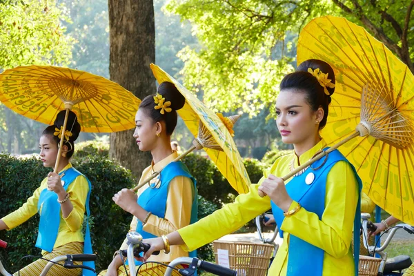 Gadis dalam gaun tradisional memegang payung naik sepeda ar — Stok Foto