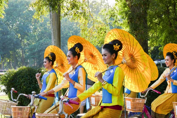 Girl in traditional dress holding umbrella riding the bicycle ar — Stock Photo, Image