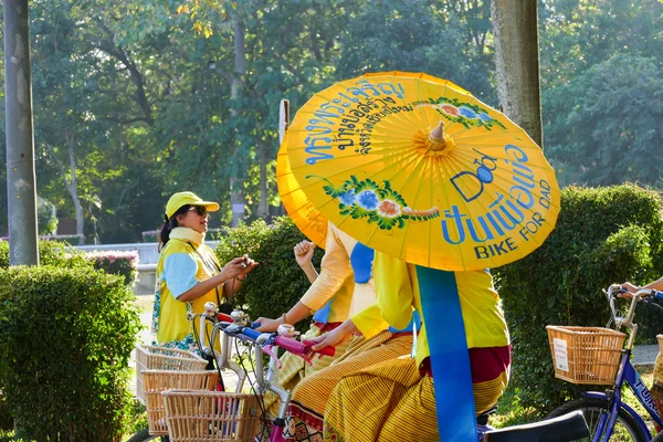 Ragazza in abito tradizionale che tiene l'ombrello in sella alla bicicletta ar — Foto Stock