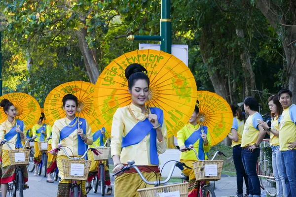 Mädchen in traditioneller Kleidung mit Regenschirm auf dem Fahrrad — Stockfoto
