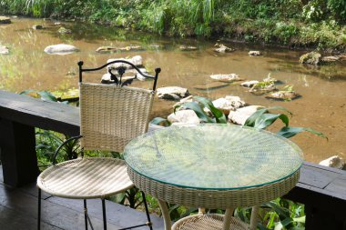 Beyaz rattan hasır sandalye ve masa terasta