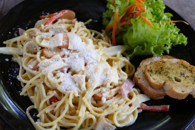 Sarımsaklı ekmek ile hizmet veren carbonara spagetti