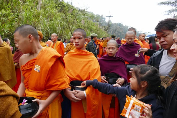 Люди дают пищу буддистскому монаху в пищу, предлагая традиционные c — стоковое фото