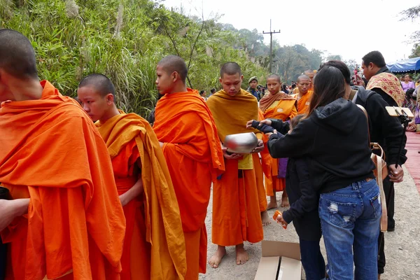 Люди дают пищу буддистскому монаху в пищу, предлагая традиционные c — стоковое фото