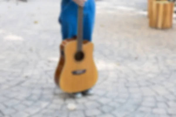 Κοπέλα φορώντας τζιν και ύπουλος κρατώντας κιθάρα — Φωτογραφία Αρχείου