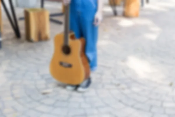 Girl wearing blue jeans and sneaker holding guitar — Stock Photo, Image