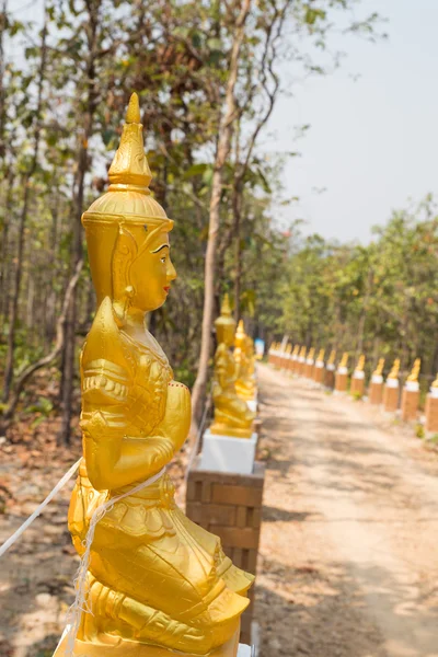 Золотой азиатский ангел статуя рядом с дорожкой — стоковое фото