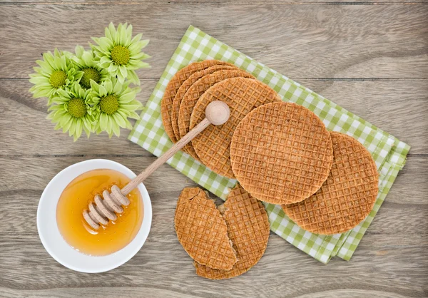 Waffles holandeses com mel no fundo de madeira — Fotografia de Stock