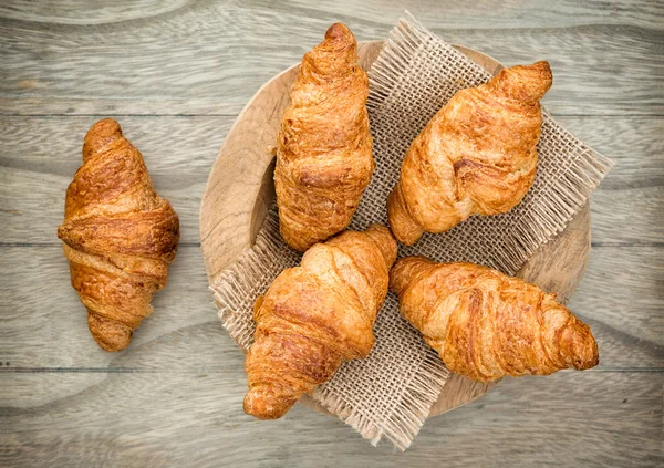 Croissant appena sfornati sul tavolo di legno — Foto Stock