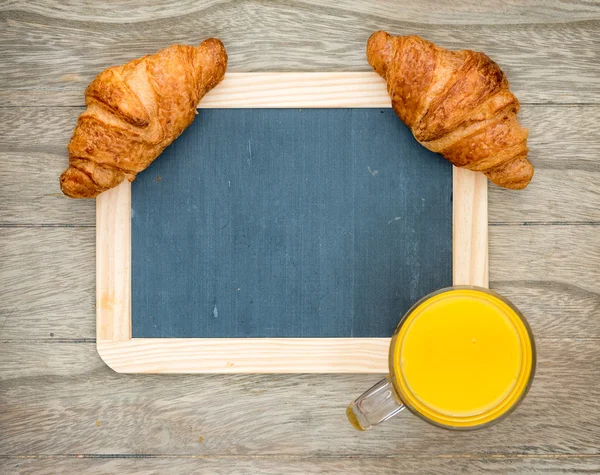 Croissants frescos assados na mesa de madeira — Fotografia de Stock