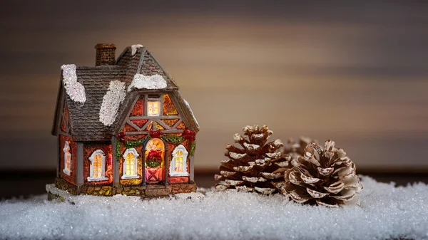 Maison de Noël et cône de pin dans la neige — Photo