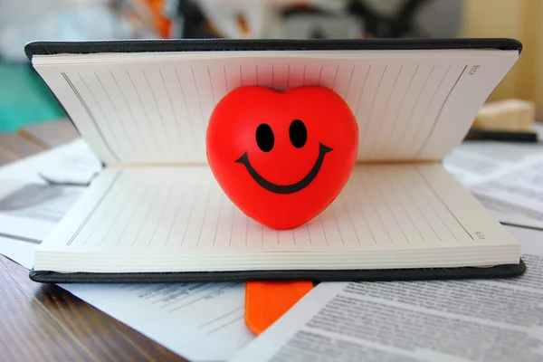 Açık kitap fotokopi alanında gülen yüzlü kırmızı kalp, aşk konsepti