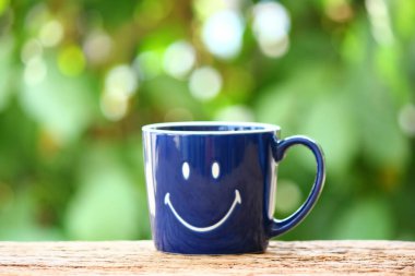 Geçmişin yeşil zemininde gülücük desenli mavi seramik kahve fincanı