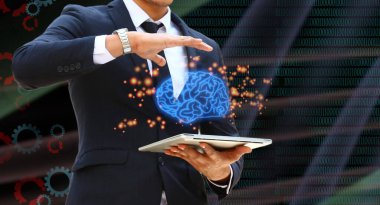 Mavi takım elbiseli iş adamı elinde dizüstü bilgisayarla soyut arka planda beyin fuarının resimlerini tutuyor. Gelecekteki dizüstü bilgisayar teknolojisi insan beyni kadar zeki olacak. Teknoloji konsepti.