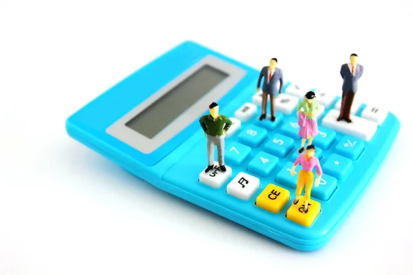 Hesap makinesi üzerinde duran minyatür insan modeli beyaz üzerine izole et