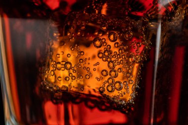 Yakın plan buzlu bir bardak kola. Buz küpleri ve soda köpükleri. Makrofoto