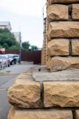 Dışarıdaki bir binanın tuğla duvarı. Tuğla ve çimentodan yapılmış güzel bir sokak duvarı..