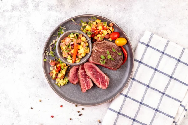 Şeftalili salsa, domates ve biberli biftek. Orta pişmiş ya da az pişmiş biftek. Yemek hazır. Üst görünüm. 