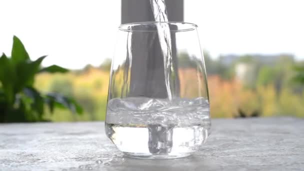 純水をガラスに注ぐ カメラが動き回る パララックス効果 クローズアップ映像 — ストック動画