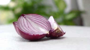 Taze dilimlenmiş soğanlar masada dönüyor. Kamera hareket ediyor. Parallaks etkisi. Yakın çekim görüntüleri.