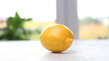 Olgun sulu limon masada dönüyor. Kamera hareket ediyor. Parallaks etkisi. Yakın çekim görüntüleri.