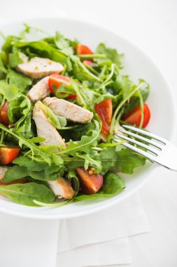Fresh salad with chicken, tomato and greens (spinach, arugula)